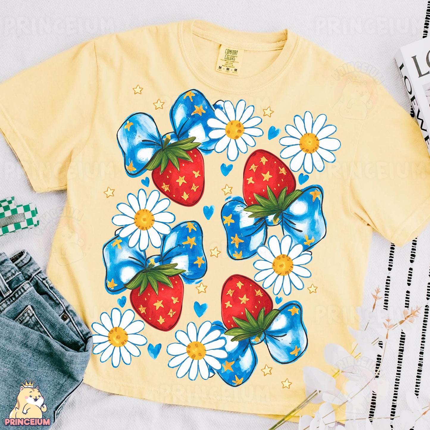 a yellow shirt with a blue bow and a strawberry on it