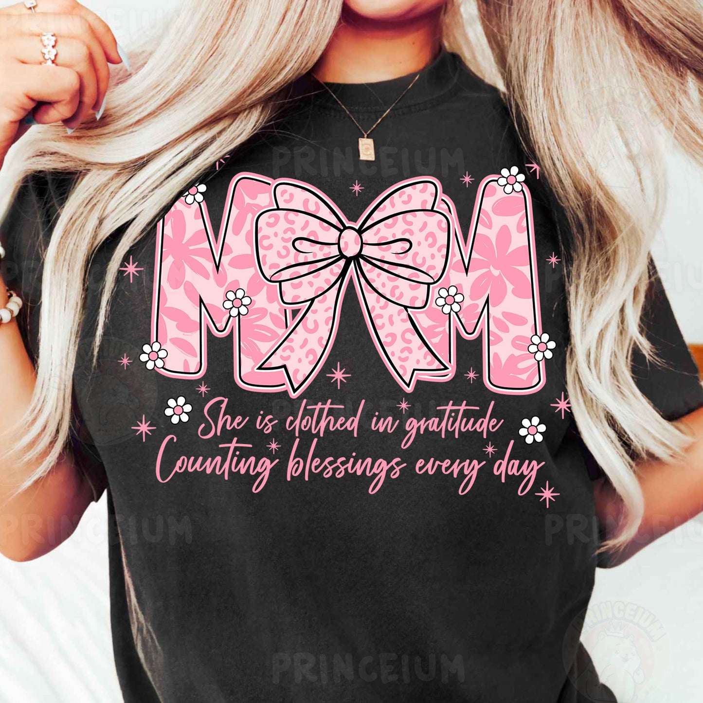 a woman wearing a mom shirt with a pink bow
