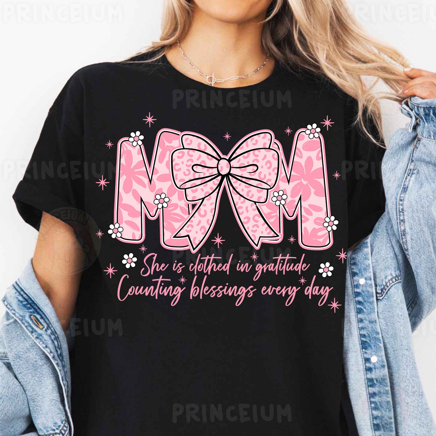 a woman wearing a black mom shirt with a pink bow
