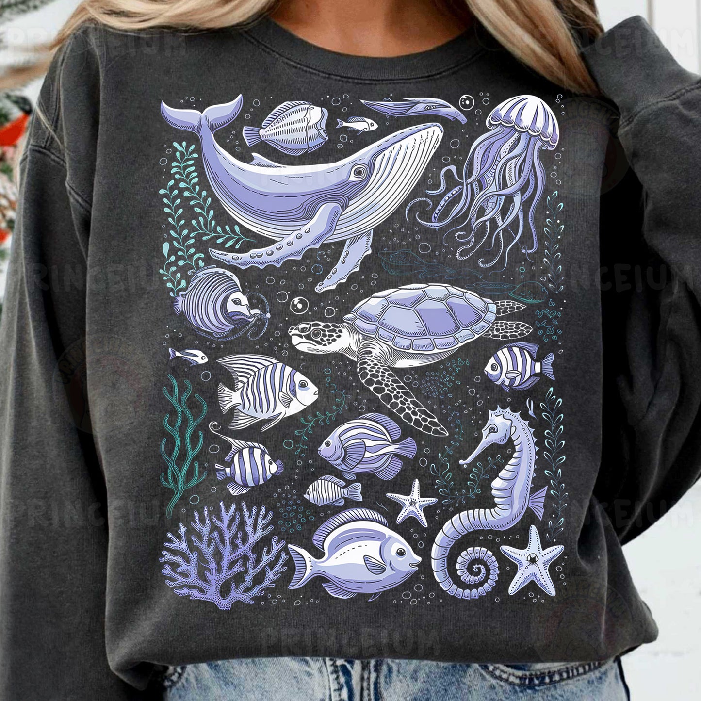 a woman wearing a sweatshirt with a picture of a whale and other sea animals on