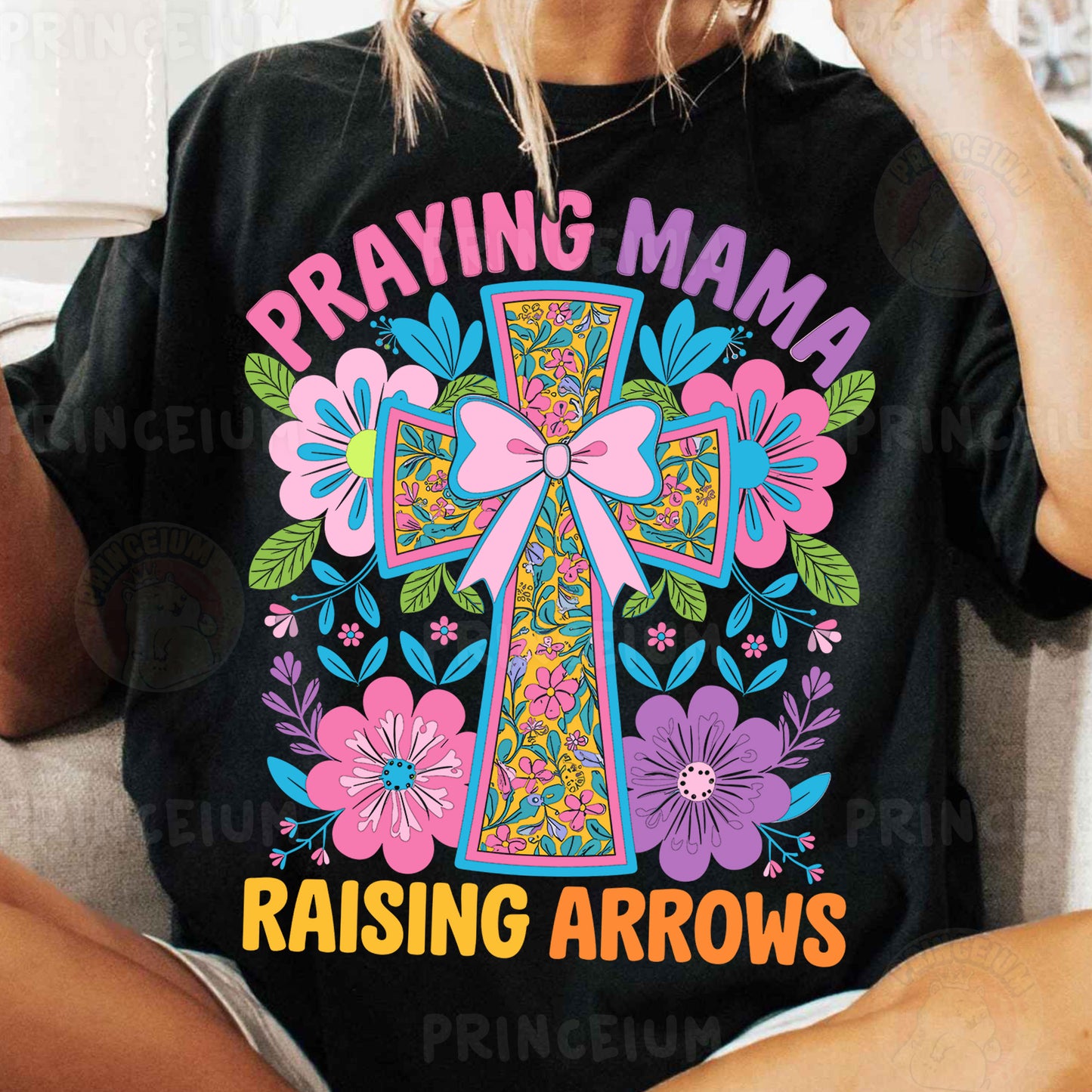 a woman sitting on a couch wearing a t - shirt with a cross on it