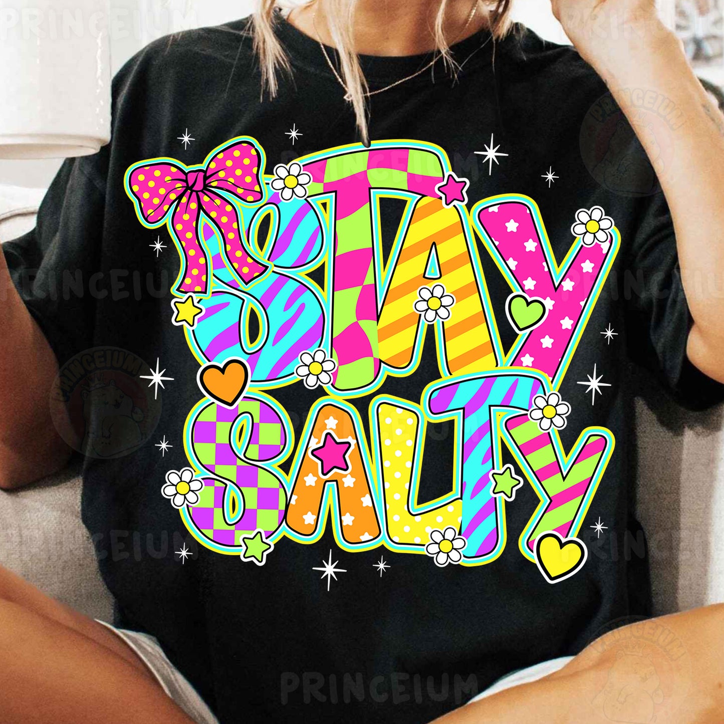a woman sitting on a couch wearing a t - shirt that says stay salty