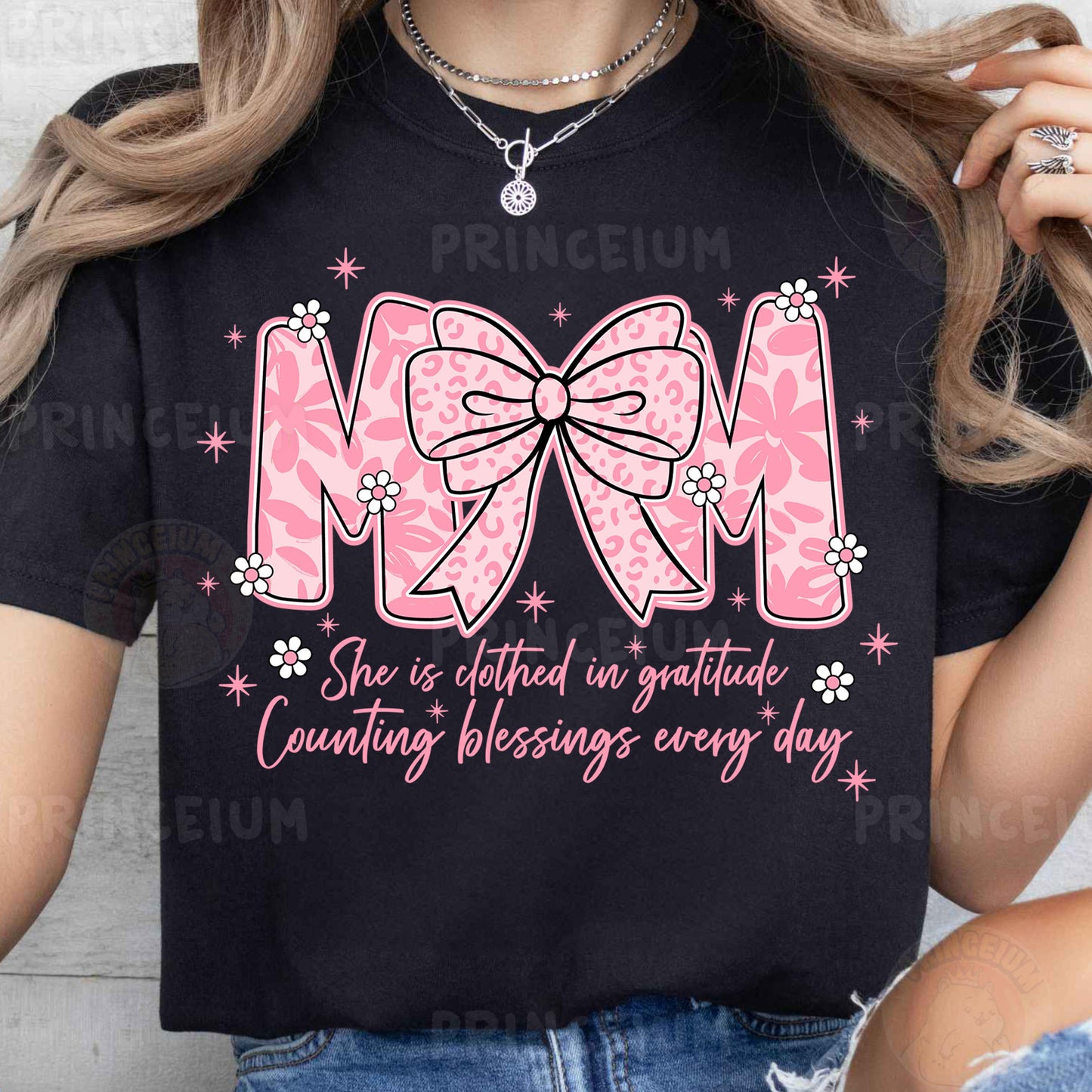 a woman wearing a mom shirt with a pink bow