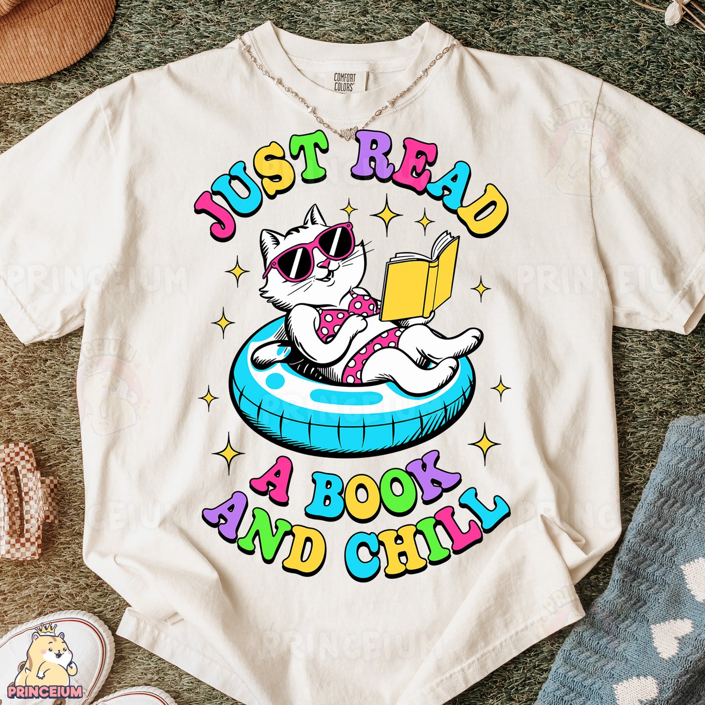 a white t - shirt with a cat reading a book and sunglasses
