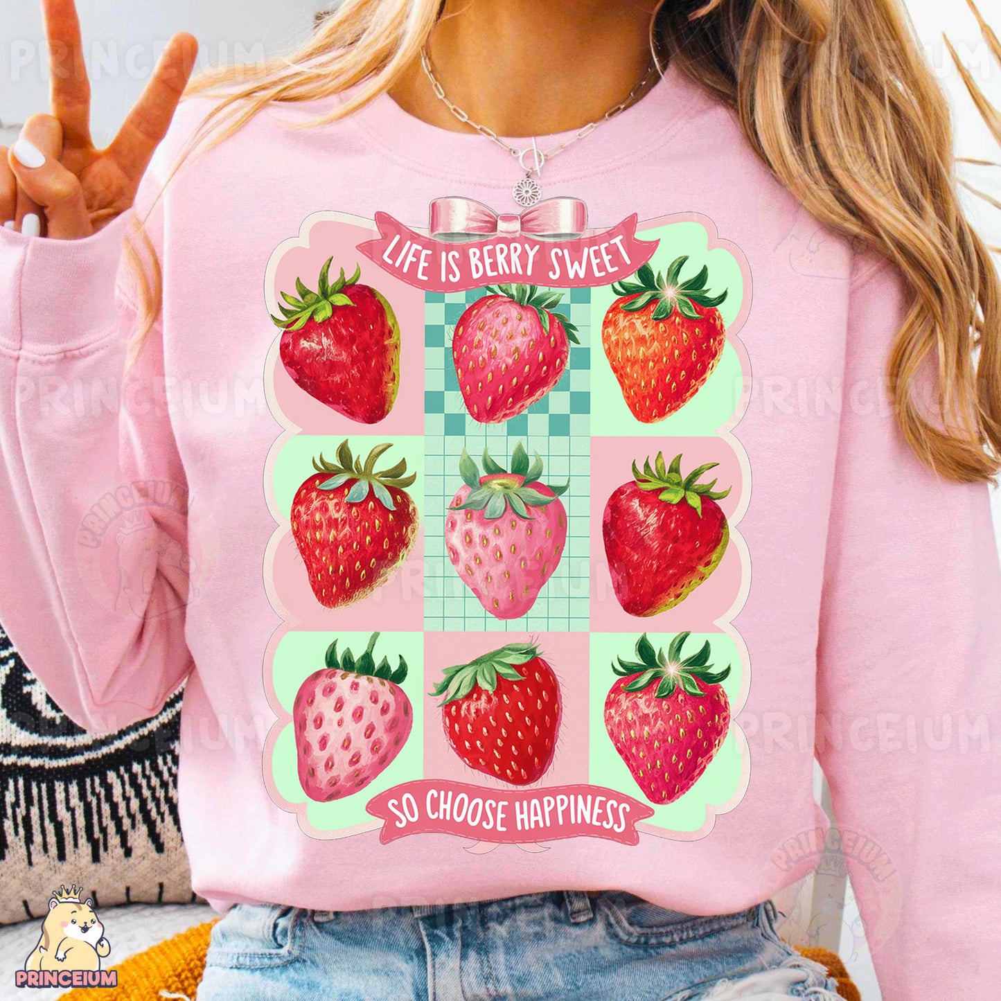 a woman wearing a pink sweatshirt with a graphic of strawberries on it