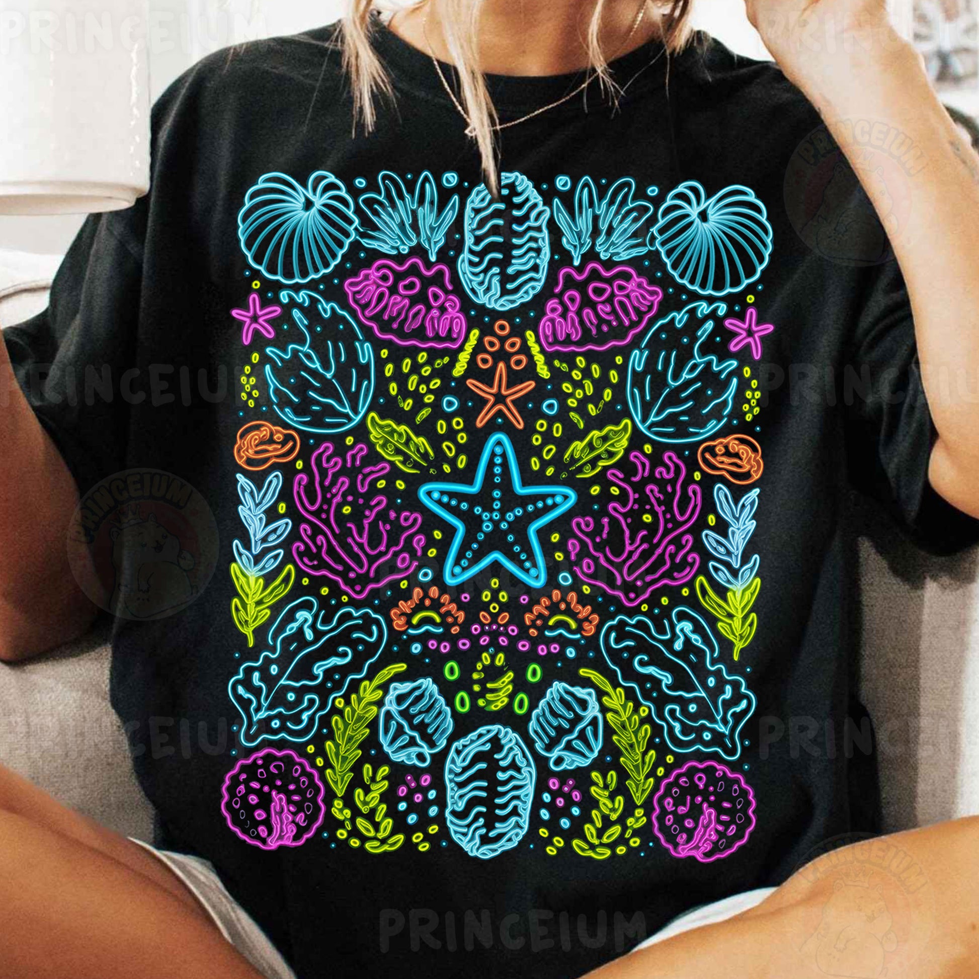 a woman sitting on a couch wearing a black shirt with a colorful design on it