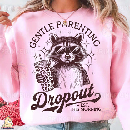 a woman wearing a pink sweatshirt with a raccoon holding a drink