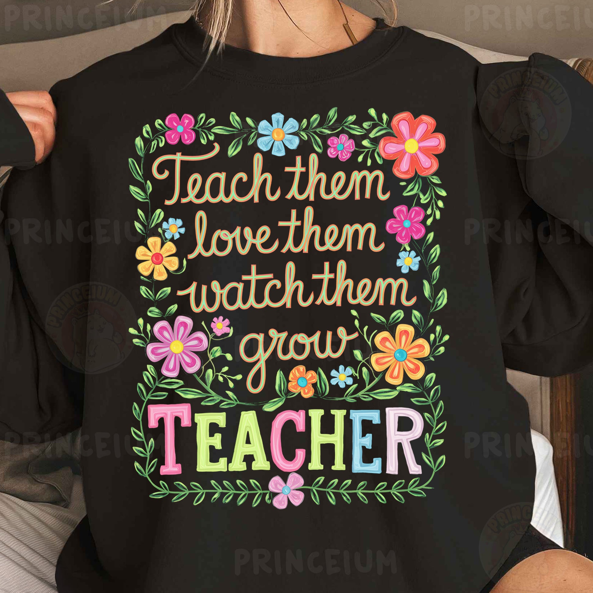 a woman wearing a black teacher shirt with flowers on it