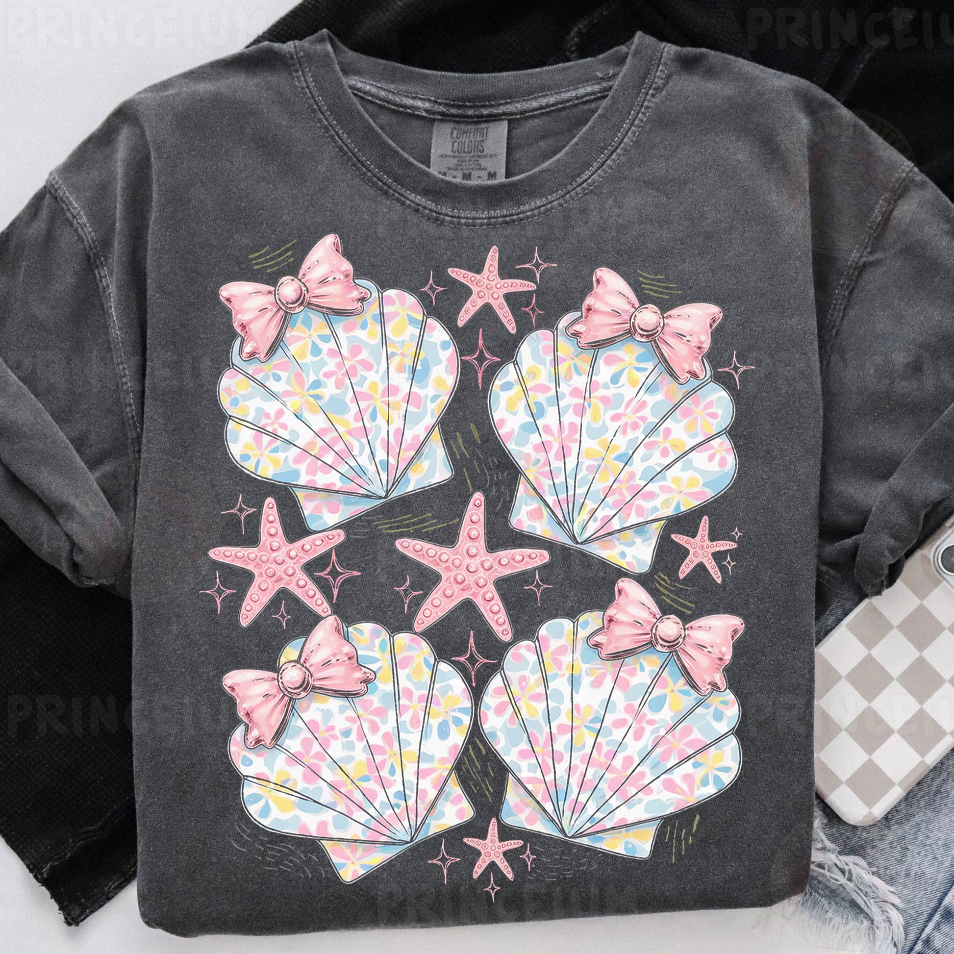 a black shirt with pink bows and seashells on it