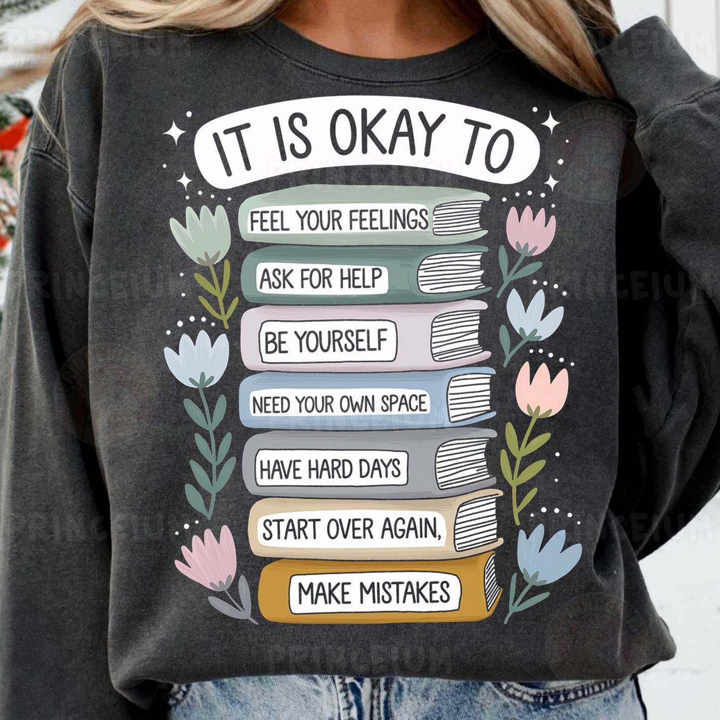 a woman wearing a sweatshirt with a stack of books on it