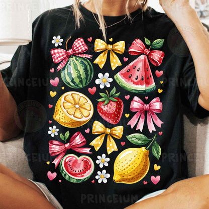 a woman sitting on a couch wearing a black shirt with fruit on it