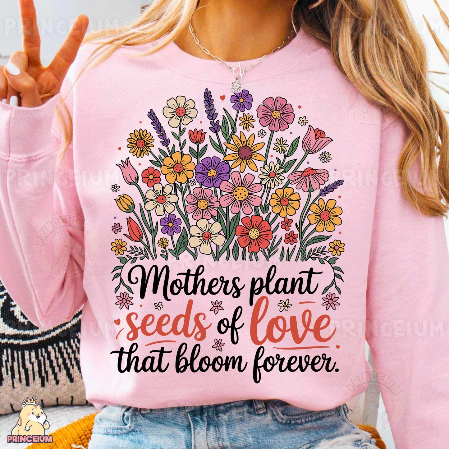 a woman wearing a pink shirt that says mothers plant seeds of love that bloom forever