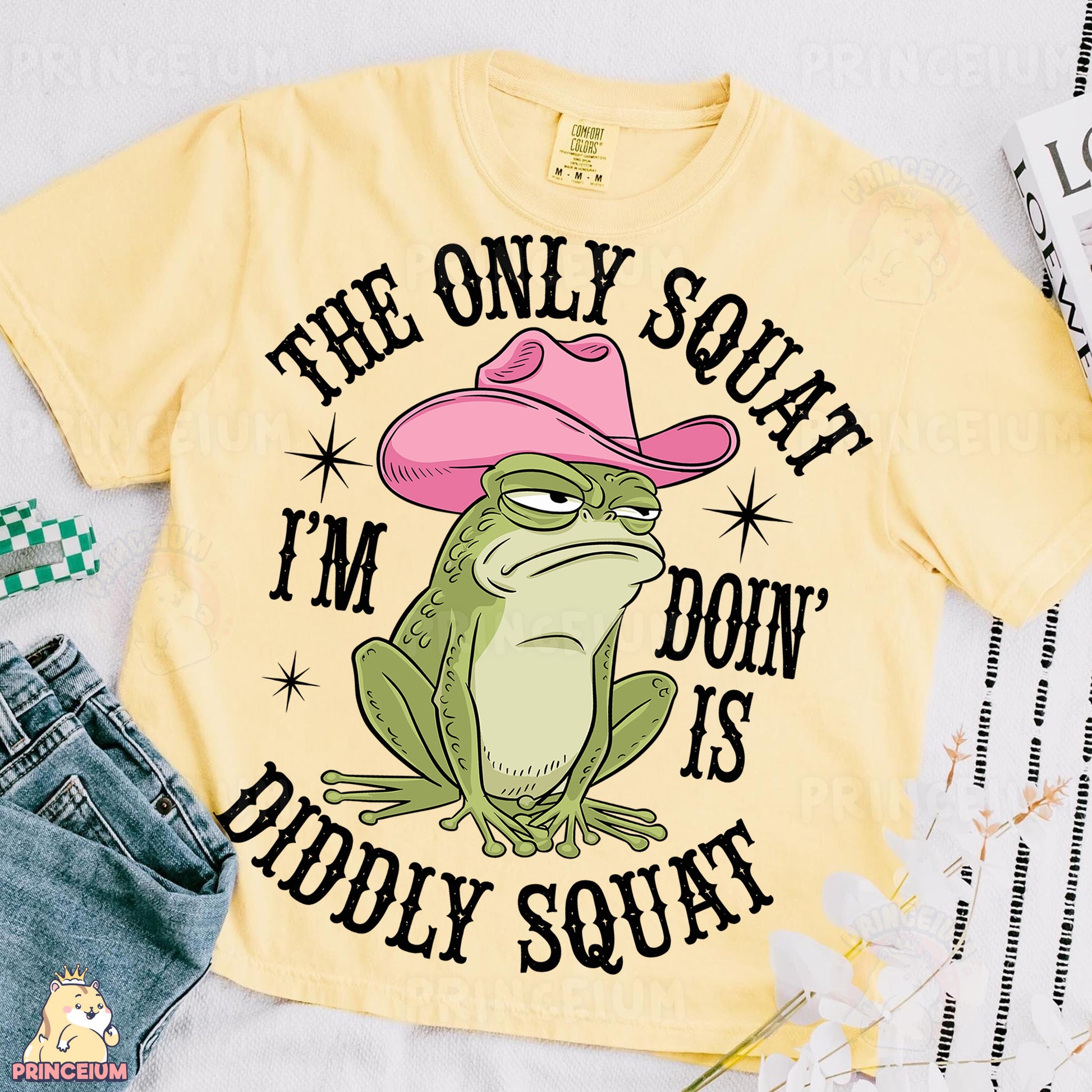 a yellow shirt with a frog wearing a pink cowboy hat