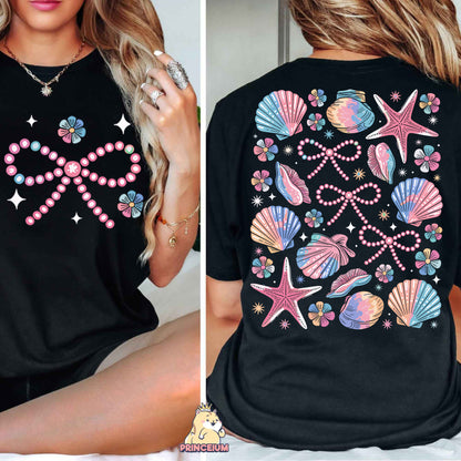 a woman wearing a black shirt with pink and blue seashells on it