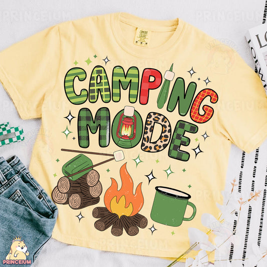 a t - shirt that says camping mode next to a pair of jeans