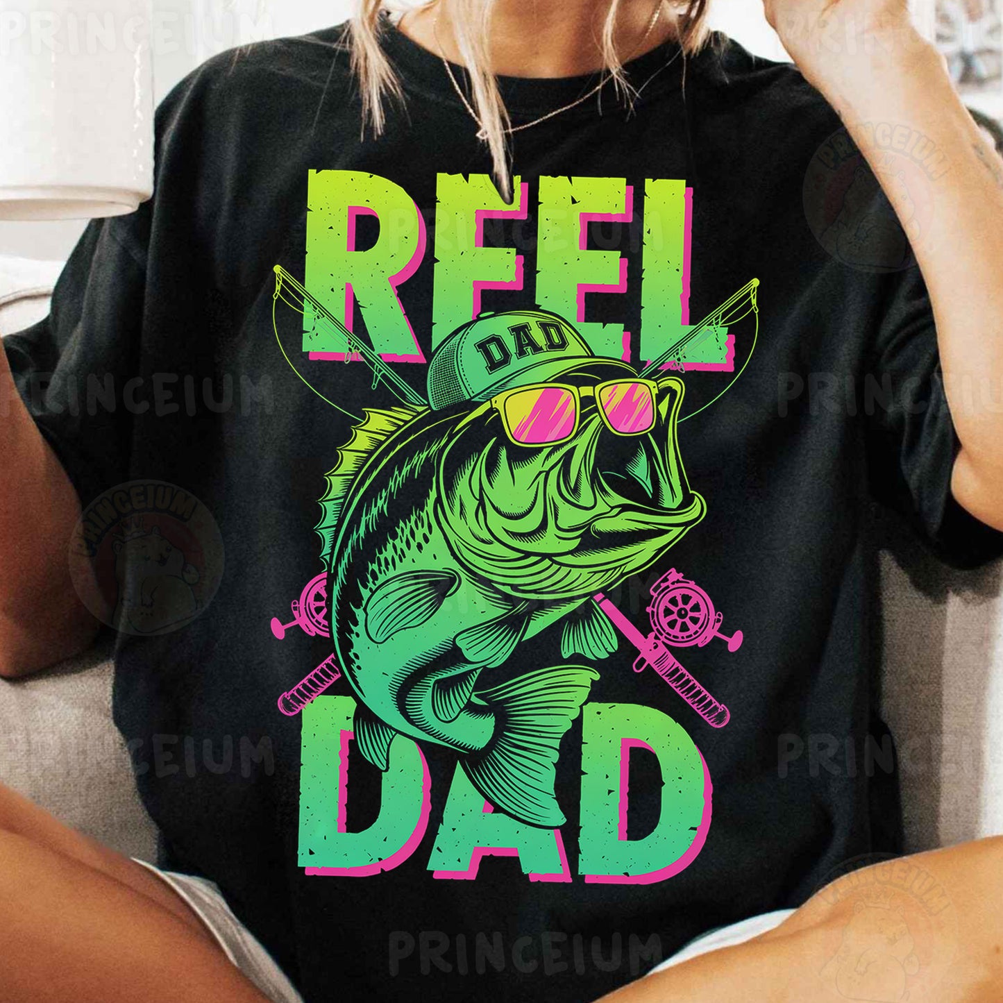 a woman sitting on a couch wearing a t - shirt that says reel dad