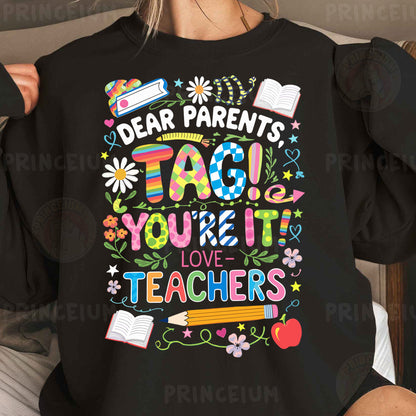 a woman wearing a black shirt that says dear parents tag you're it love