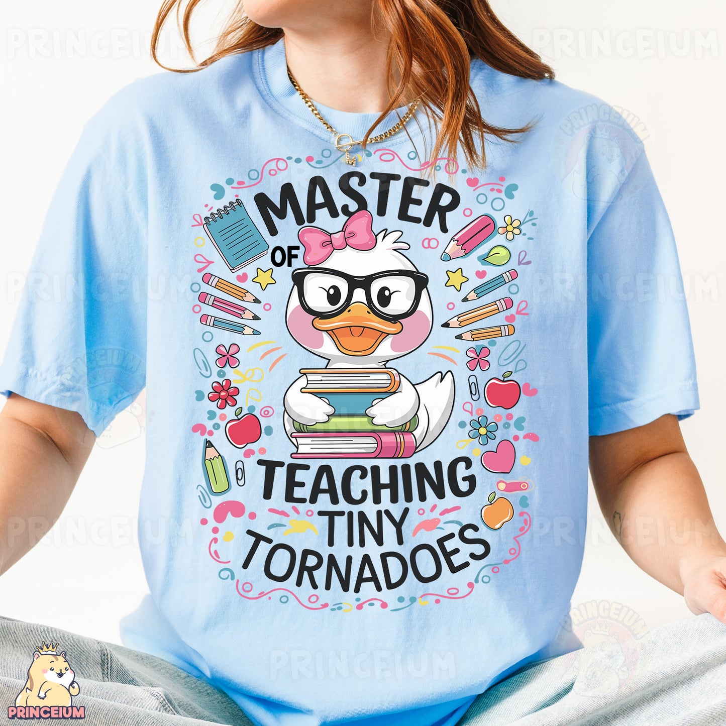 a girl wearing a blue shirt with a cartoon duck reading a book