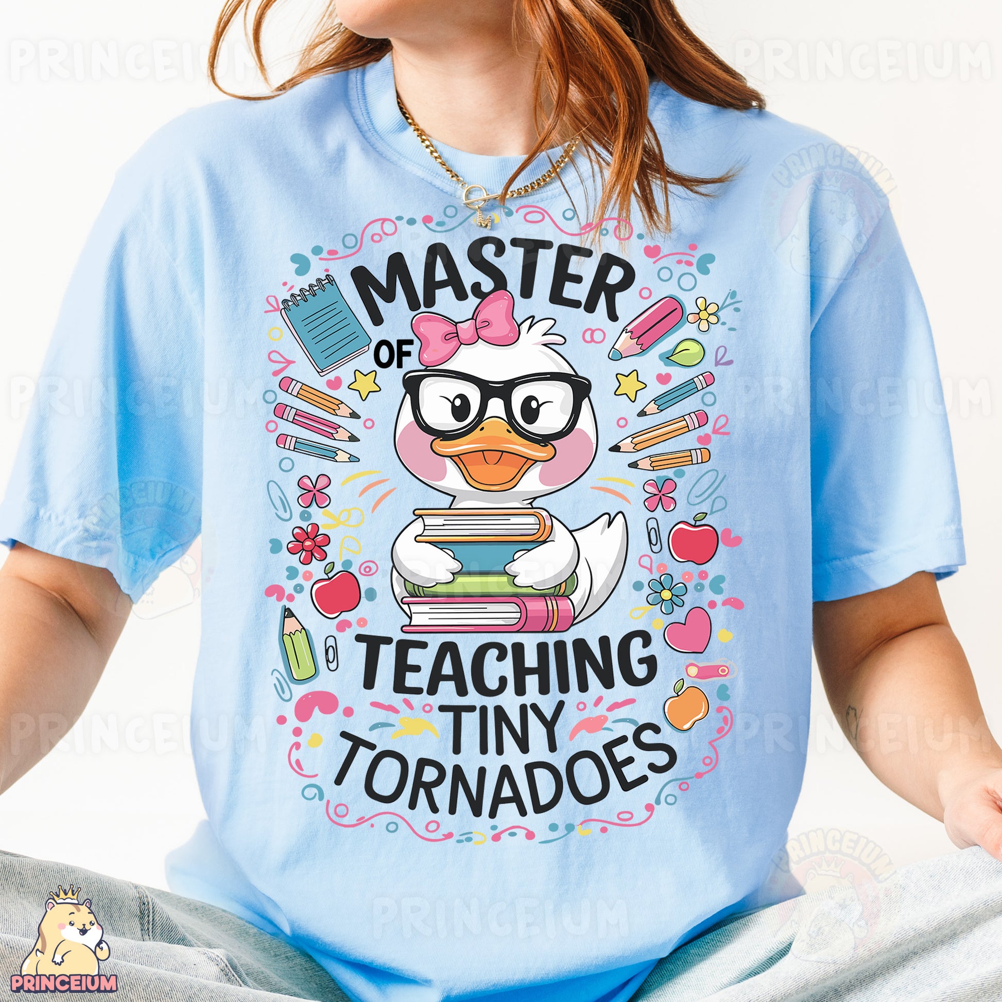 a girl wearing a blue shirt with a cartoon duck reading a book