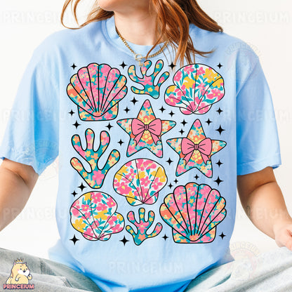 a woman wearing a t - shirt with an image of seashells on it