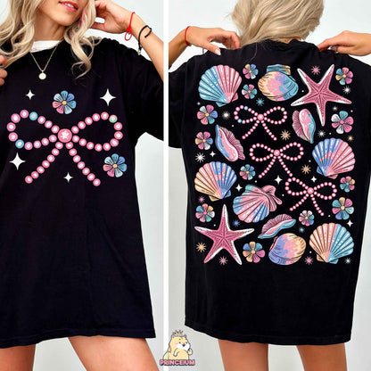 a woman wearing a black shirt with seashells on it