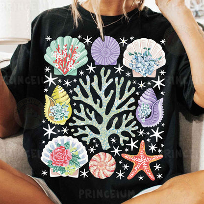a woman sitting on a couch wearing a black shirt with colorful seashells on