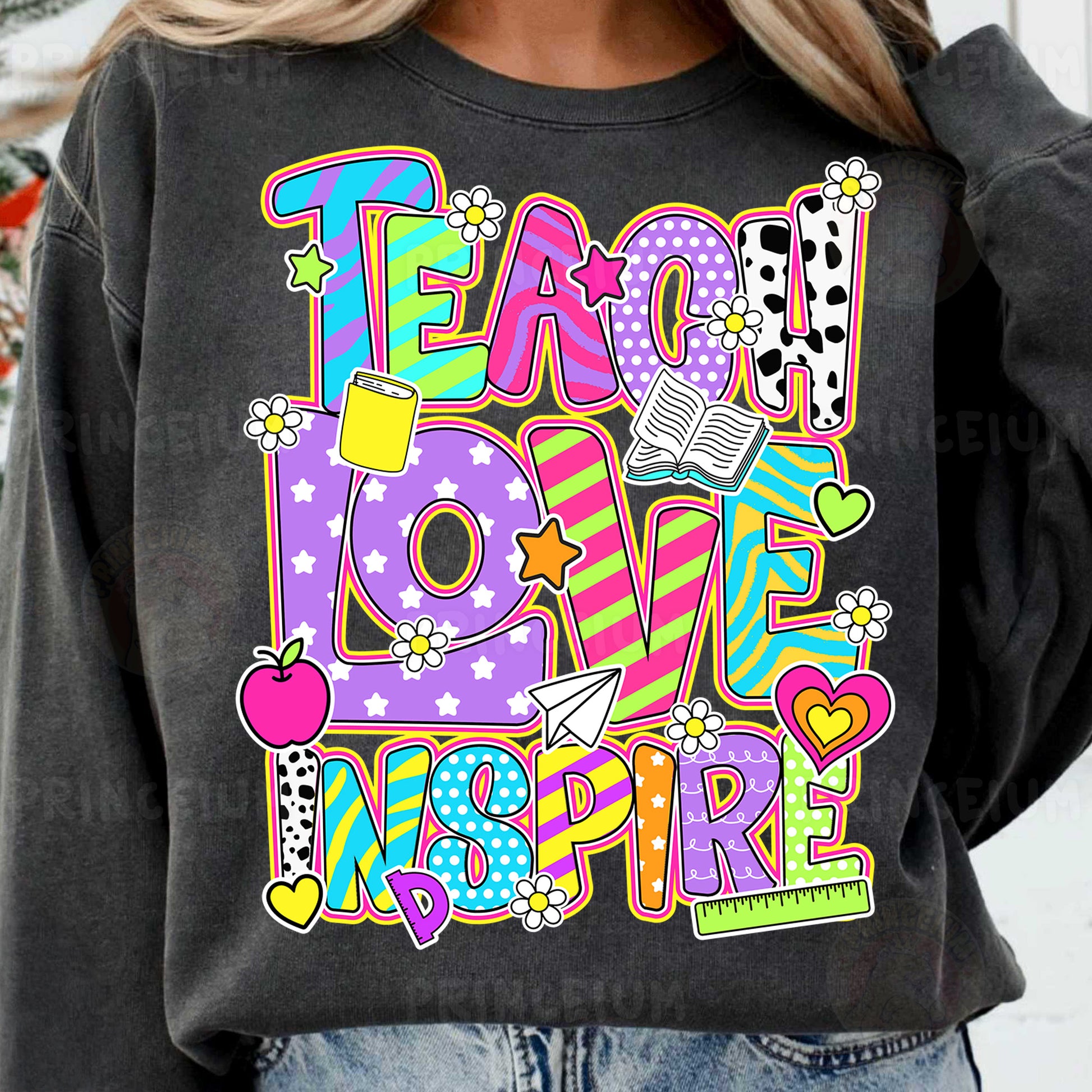 a woman wearing a black sweatshirt that says teach love inspire