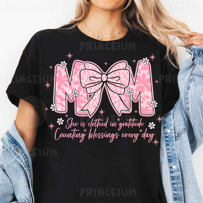a woman wearing a black mom shirt with a pink bow