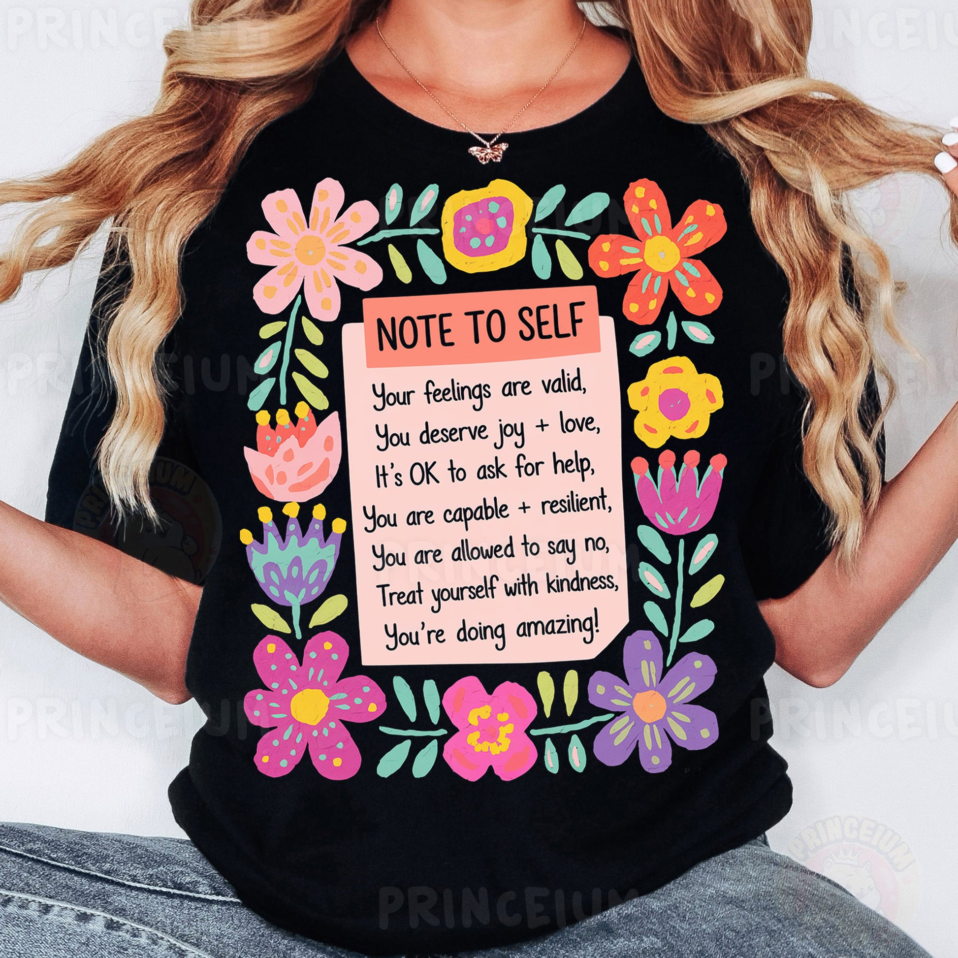 a woman wearing a black t - shirt with flowers and a note to self