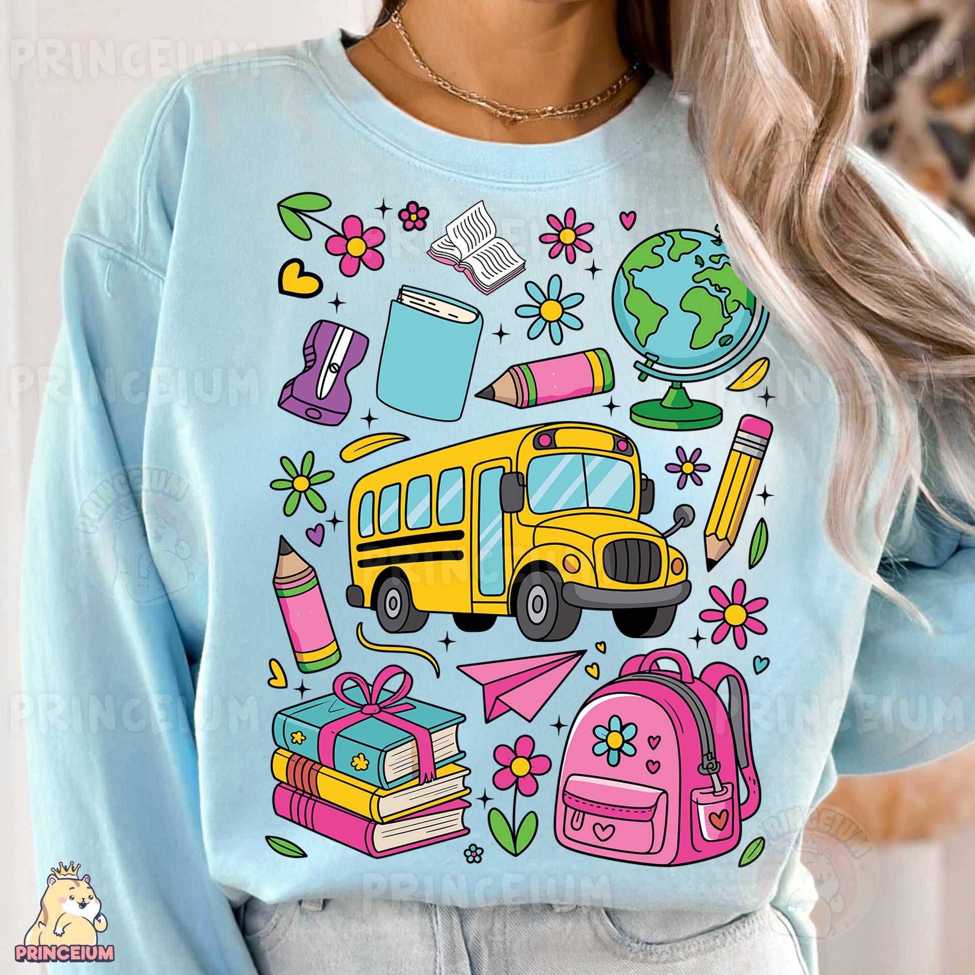 a woman wearing a blue sweatshirt with school supplies on it