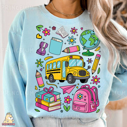 a woman wearing a blue sweatshirt with school supplies on it