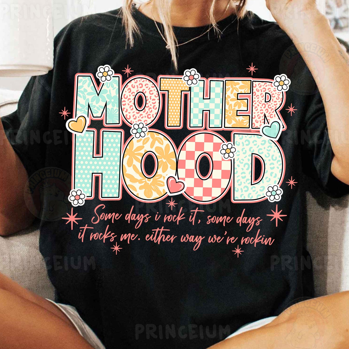a woman sitting on a couch wearing a t - shirt that says motherhood