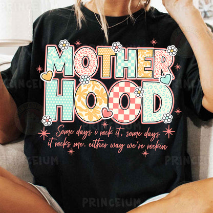 a woman sitting on a couch wearing a t - shirt that says motherhood