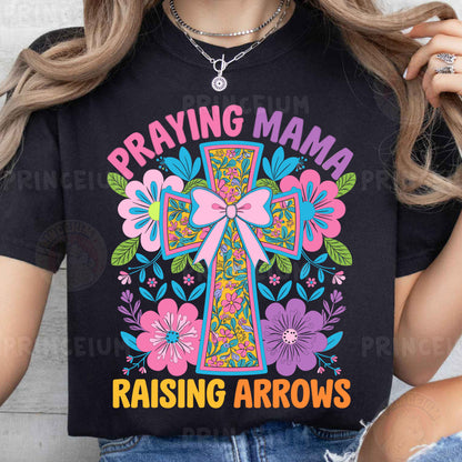 a woman wearing a t - shirt that says praying mama raising arrows