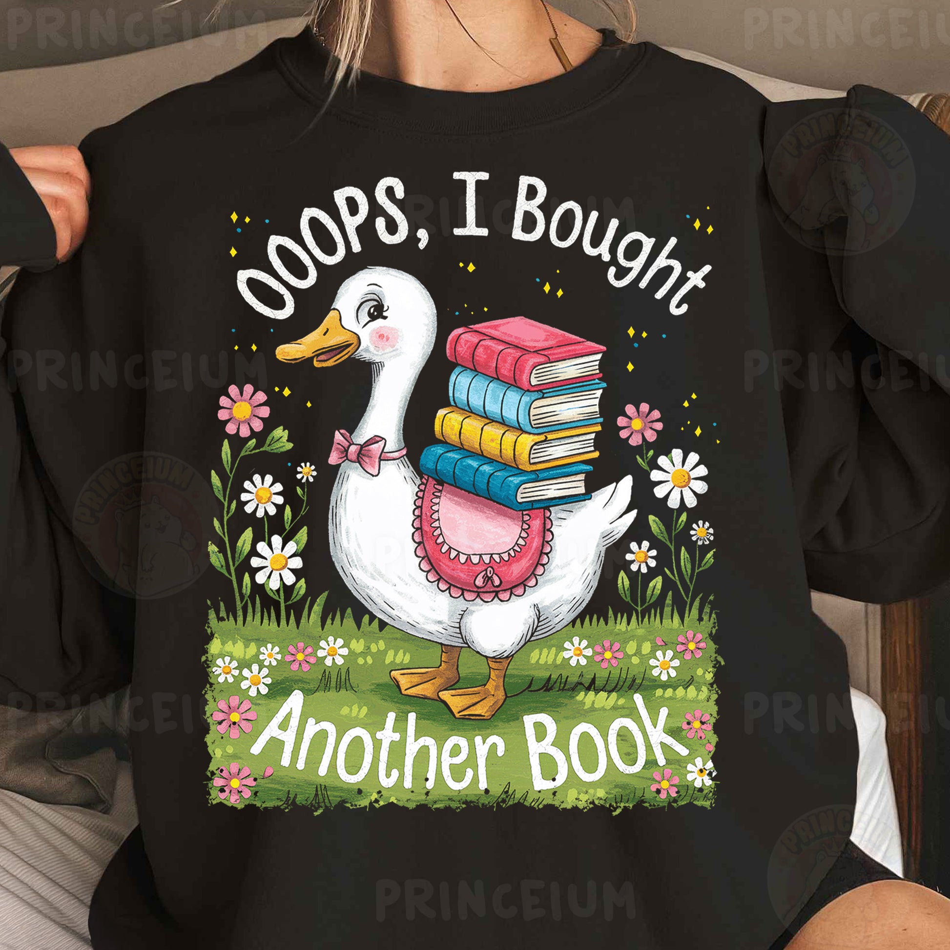 a woman wearing a black shirt with a duck holding a stack of books