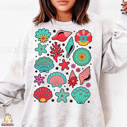 a woman wearing a white sweatshirt with colorful sea life on it