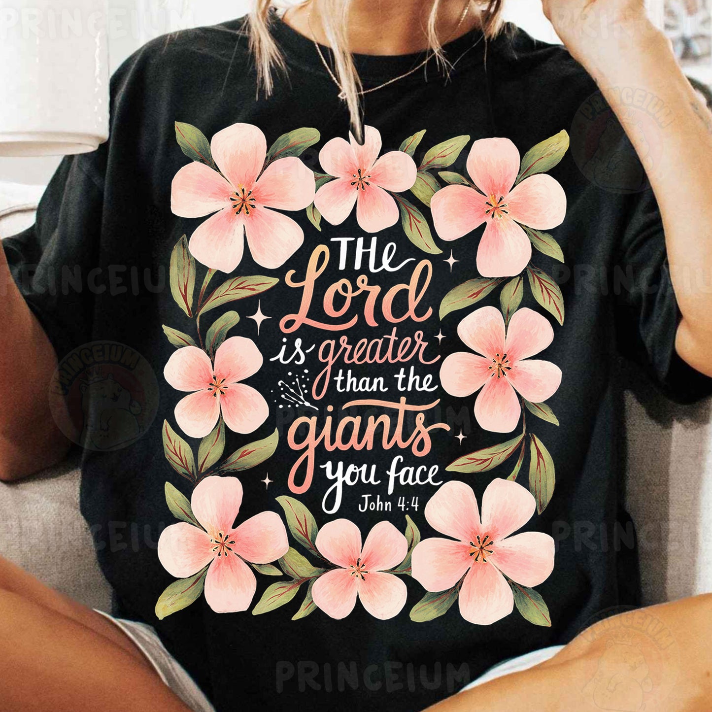 a woman sitting on a couch wearing a black shirt with pink flowers