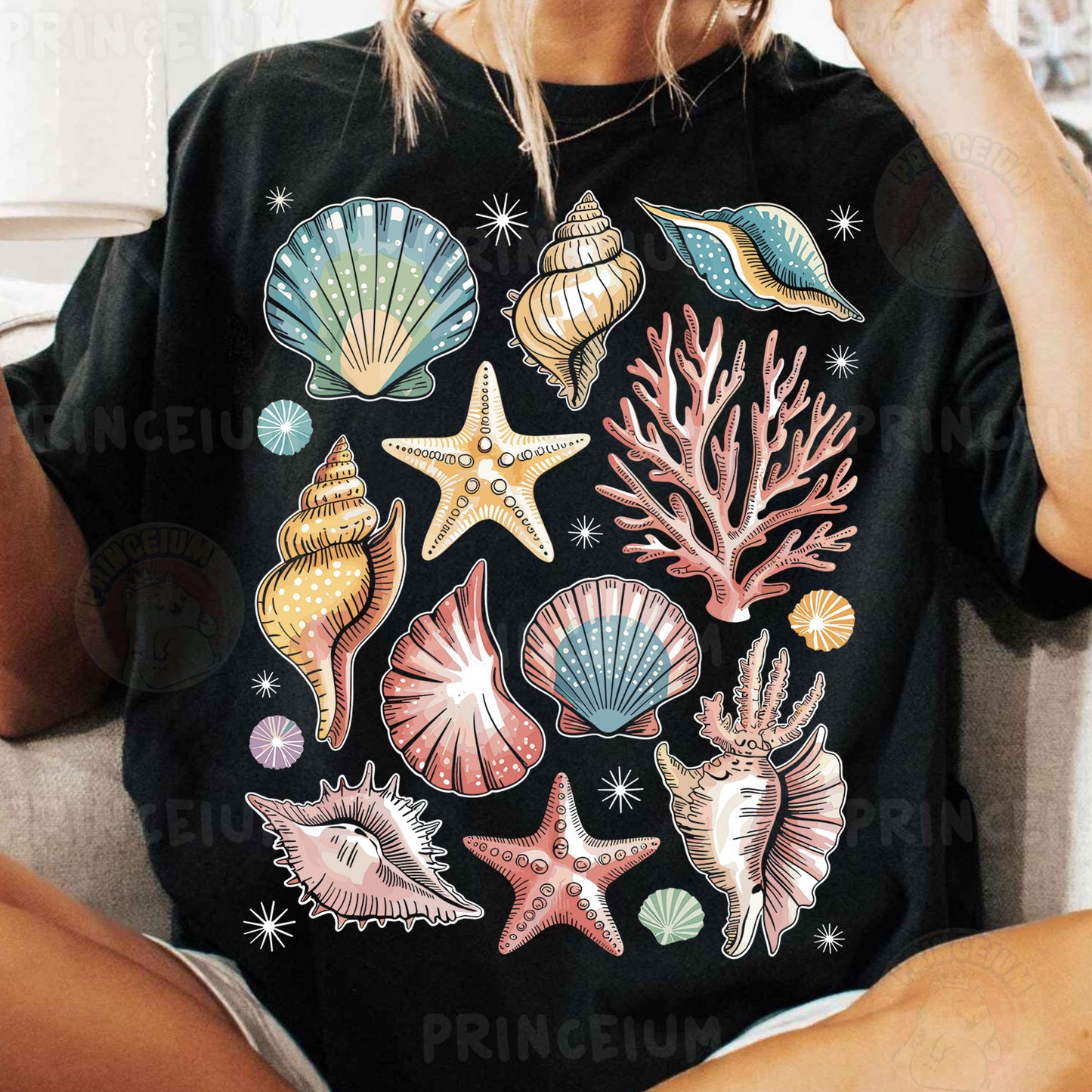 a woman sitting on a couch wearing a black shirt with sea shells and starfish