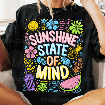 a woman sitting on a couch wearing a black shirt that says sunshine state of mind