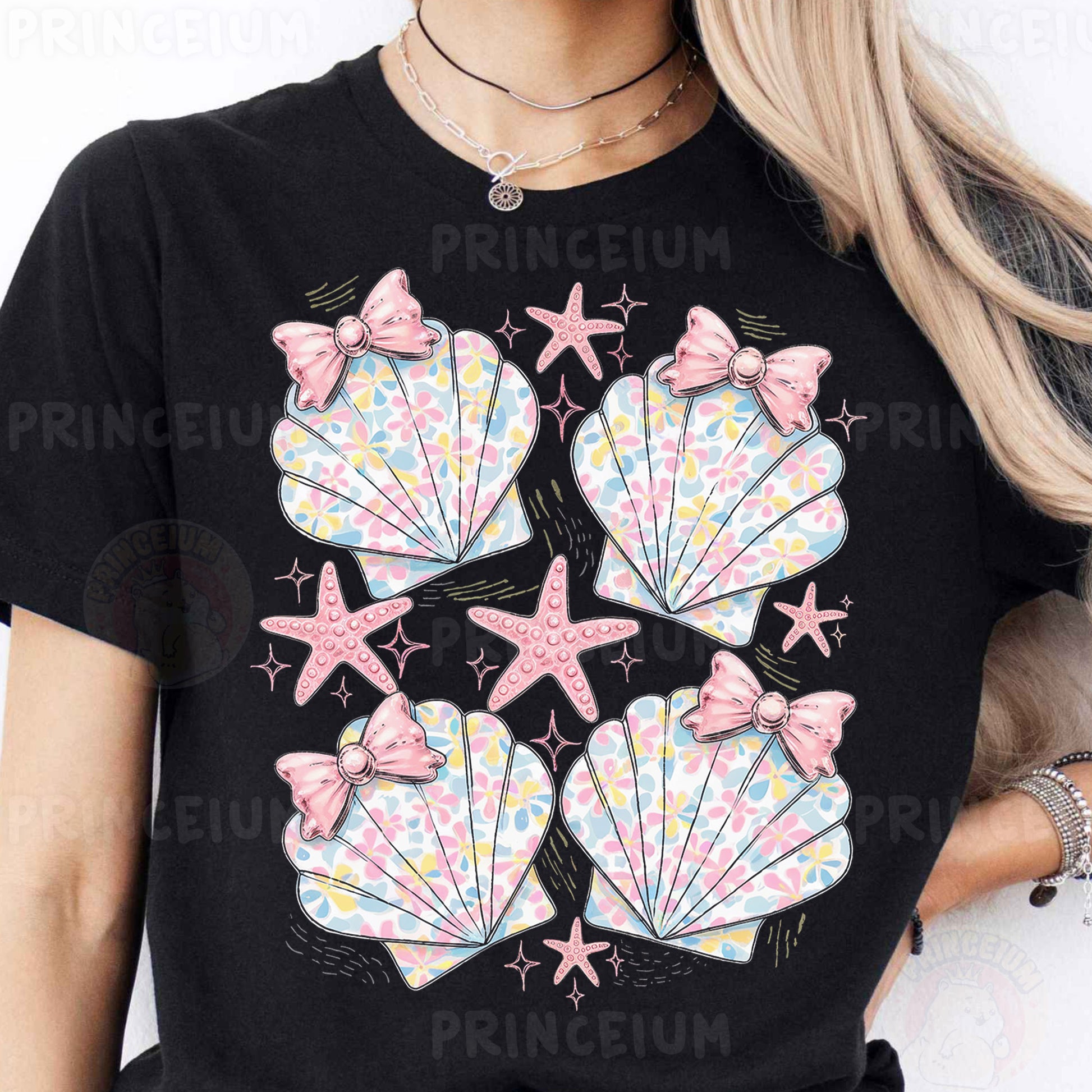 a woman wearing a black shirt with pink bows and seashells on it