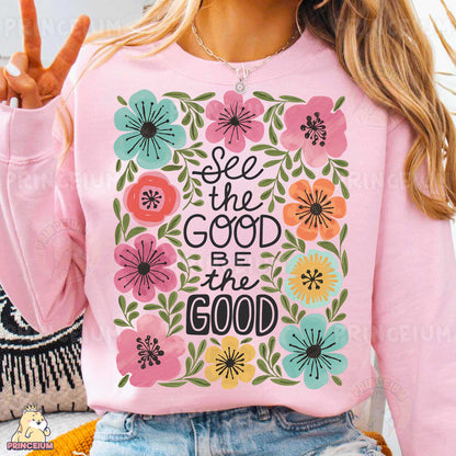 a woman wearing a pink sweatshirt with a floral design