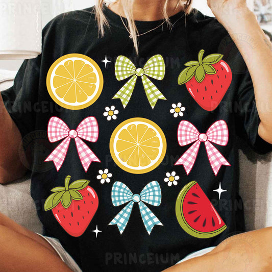 a woman sitting on a couch wearing a black shirt with fruit and bows on it
