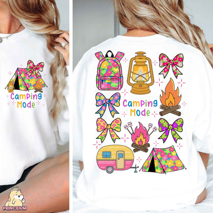 a woman wearing a white shirt with camping designs on it