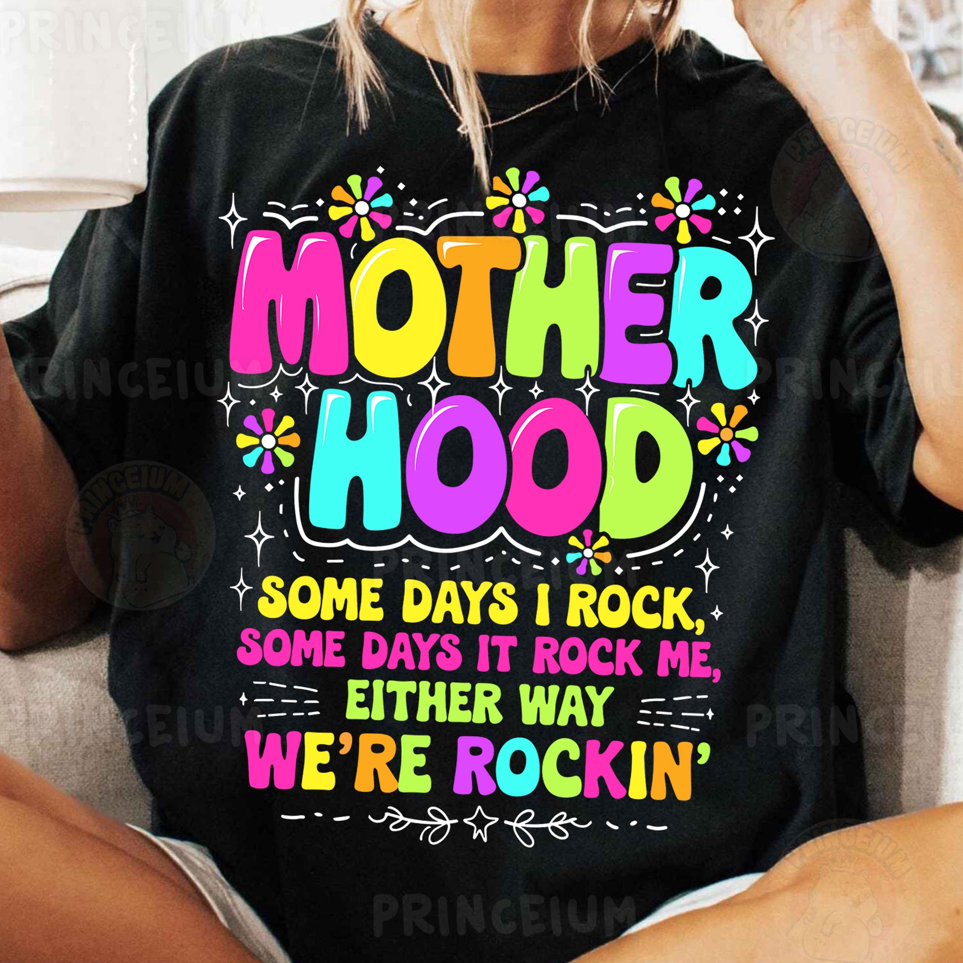 a woman sitting on a couch wearing a t - shirt that says motherhood