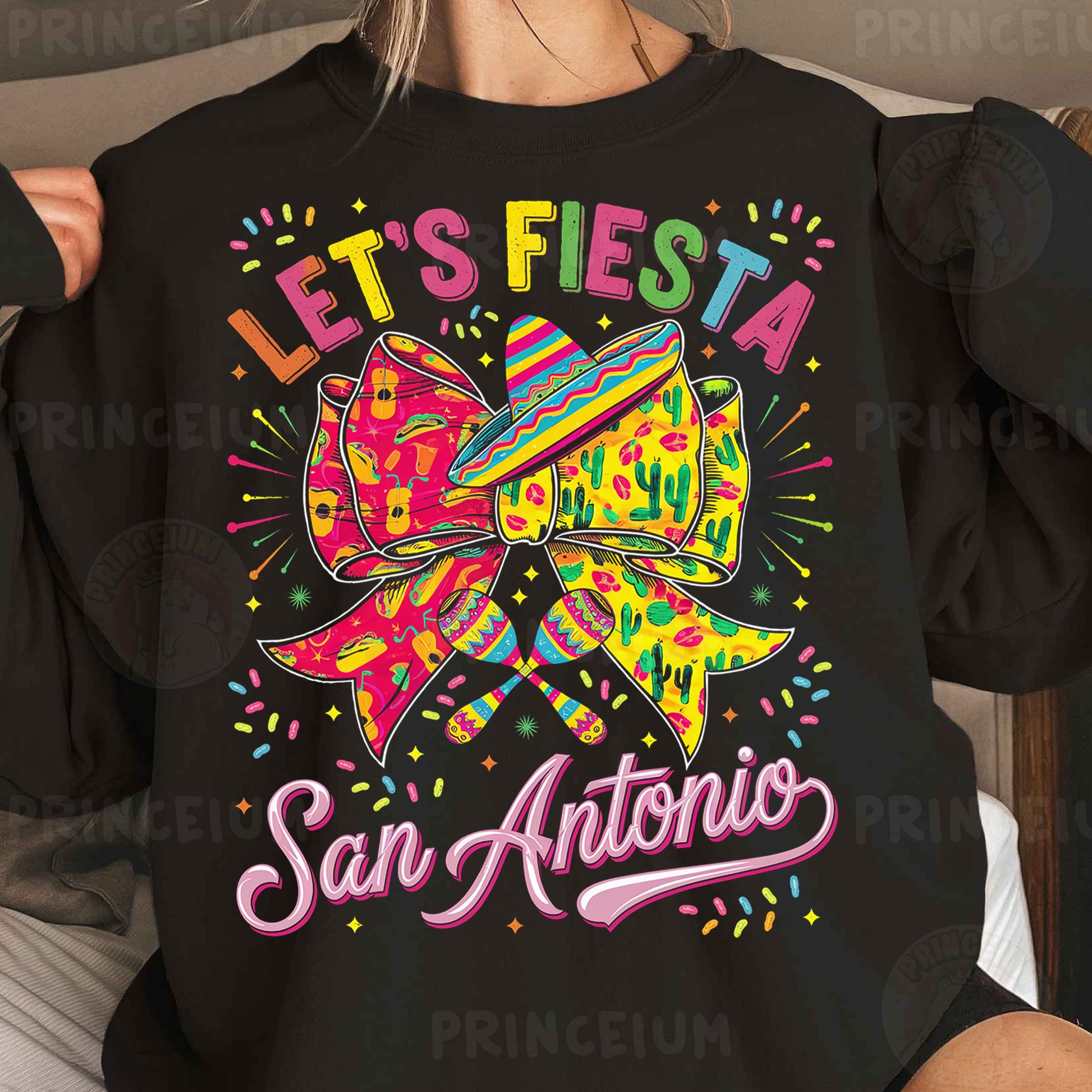 a woman wearing a black sweatshirt that says let's fiesta san antonio