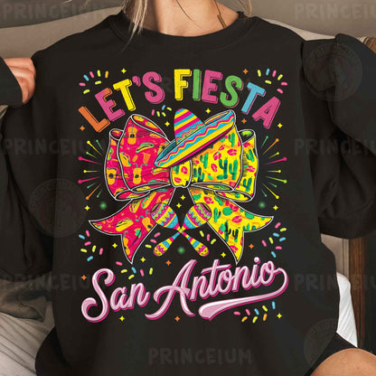 a woman wearing a black sweatshirt that says let's fiesta san antonio