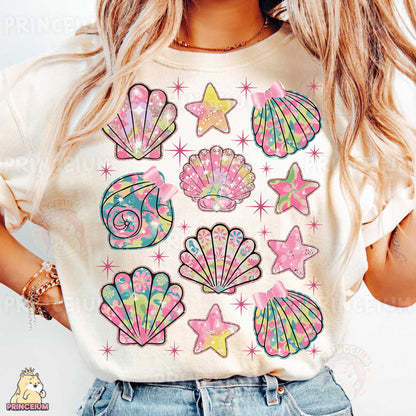 a woman wearing a t - shirt with shells and stars on it