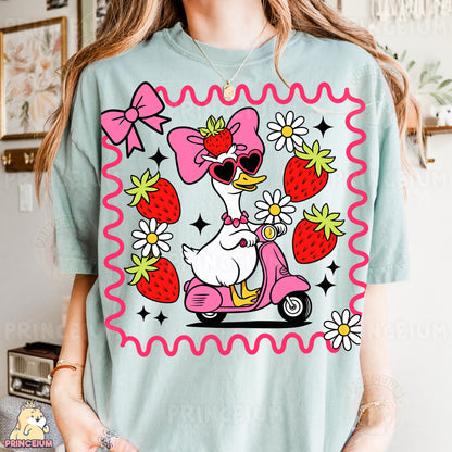 a woman wearing a t - shirt with an image of a duck riding a sc