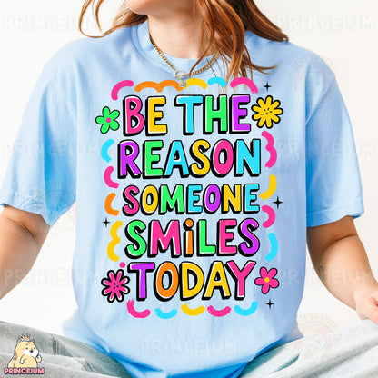 a woman wearing a t - shirt that says be the reason someone smiles today