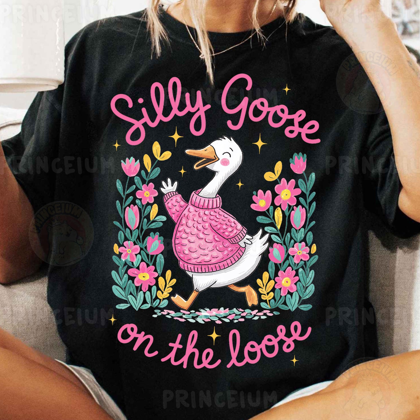 a woman sitting on a couch wearing a t - shirt with a goose on it